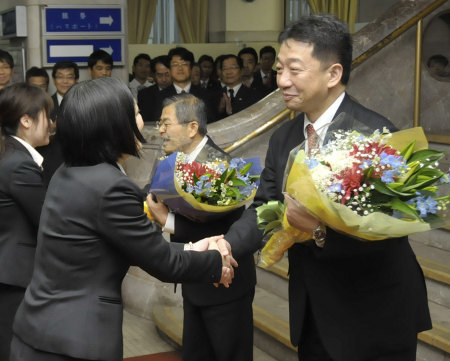 離任式で職員から花束を受け取る内田副知事 右 と稲用副知事