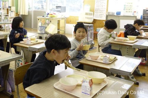 ヤマメの唐揚げを頬張る児童たち